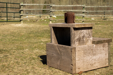 Pair of Dirty Black Well Worn Polo Wraps on A Mounting Block in a Round Pen Riding Arena with a Rural Farm Fence and Space for Text