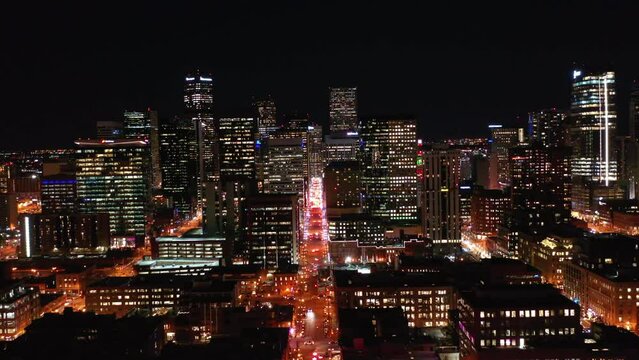 Aerial Forward Shot Of Illuminated Modern Buildings In City Against Clear Sky At Night - Denver, Colorado
