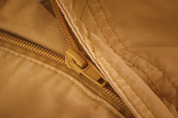 The zipper on beige pants. Close up.