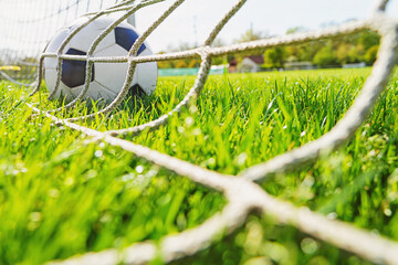 textured soccer game field with close-up ball in front of the soccer goal - soccer ball in soccer...