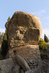 Traditonal anti pirate stone house with giant boulder roof, Ikaria island, Greece