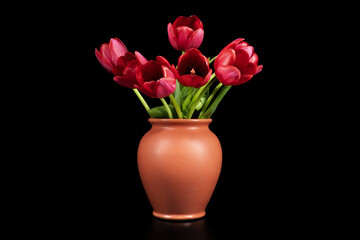Tulips in a vase on a black background