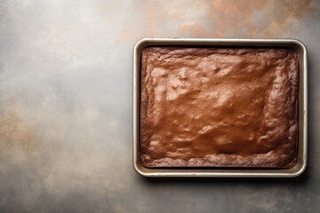 Juicy brownie on a metal tray against a minimalist or empty room background
