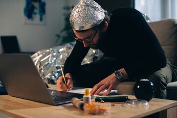 A man in a tinfoil hat is engaged in conspiracy theory. - obrazy, fototapety, plakaty