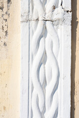 Close-up detail of facade with decorative relief fretwork in yellow and white color in the city of Rhodes in Greece