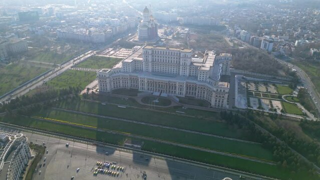 High angle drone footage of the Palace of the parliament in Bucharest Romania. Constitution Square seen from above on a sunny green day. Ceausescu's palace seen from above. Flyover shot
