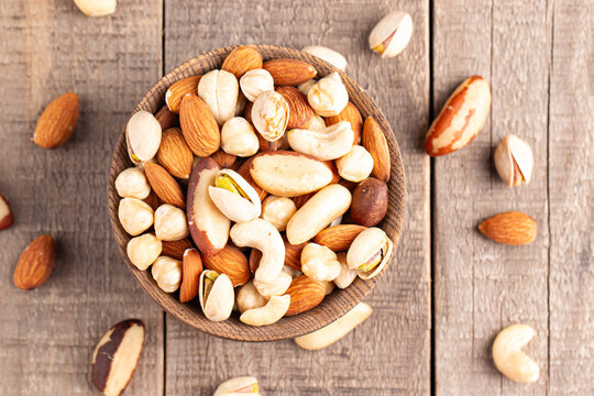 Healthy mix nuts on wooden background. Almonds, hazelnuts, cashews, peanuts, pistachios, Brazil nuts