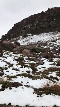 Whispering winter journey: a mesmerizing view of snow-capped mountains from the warmth of a moving car