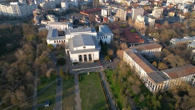 High angle aerial footage of the Bucharest National Opera House. Drone flyover shot of the building of the Johan Strauss Ensamble in the capital of Romania - Bucuresti. Sunny spring day shot.
