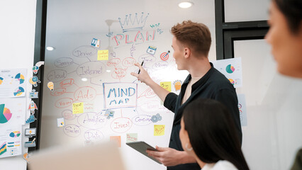 Professional male leader presents start up project by using mind map, colorful sticky notes and...