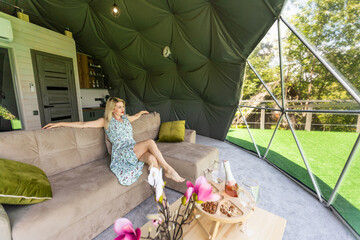 woman tourist in transparent dome hotel glamping - obrazy, fototapety, plakaty
