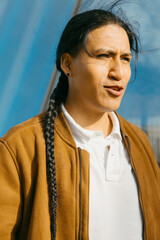 Ecuadorian man with braided hair in city setting, copy space.