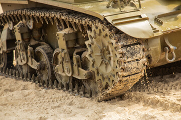 Fototapeta na wymiar Detail of an American tank from World War II. Close-up. A tank track as it travels over sand.