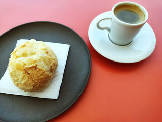 Typical brazilian snack containing traditional cheese bread and espresso coffee with red background. Food from brazilian Minas Gerais state.