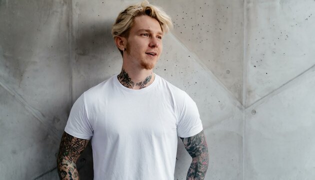 Oversize white style t-shirt mockup photo with handsome man with tattoos and light concrete background