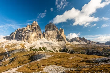 Zelfklevend Fotobehang Rocky footpaths below the monumental peak of Tre Cime with the cloudy blue sky © Simona_Mach