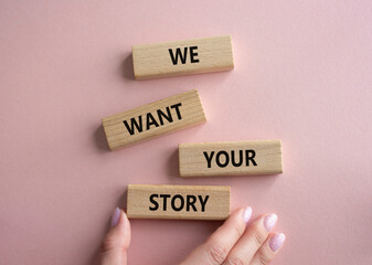 We want your story symbol. Concept words We want your story on wooden blocks. Businessman hand. Beautiful pink background. Business and We want your story concept. Copy space.