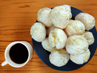 Typical brazilian snack containing traditional cheese bread and espresso coffee on the wooden background. Food from brazilian Minas Gerais state