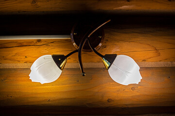 wall-mounted natural glass lamp shade on wood paneling. Eco design and comfort in the home