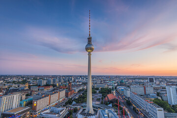 Sunset in Berlin with few clouds. Skyline of the capital of Germany in the center of the city. View of the television tower at Alexanderplatz with the Red Town Hall. Streets and high-rise buildings