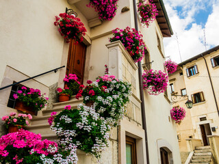 Picturesque houses adorned with colorful blooming flowers, Pescocostanzo, Abruzzo, central Italy - 767371285