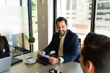 Portrait of a businessperson and boss talking to his colleagues and smiling