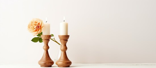 An arrangement of candles displayed on a tabletop alongside a single flower in a decorative vase