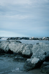 Riviera Romagnola scenic view, winter sea, rock reef, metallic and dramatic sky, stormy weather.