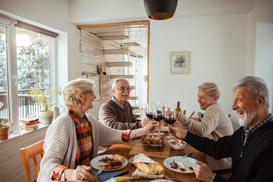 Diverse senior people eating lunch together at home