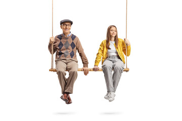 Grandfather and teenage granddaughter sitting together on a big wooden swing