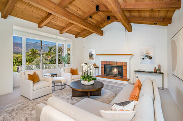 the living room has a fireplace and a huge window with a view