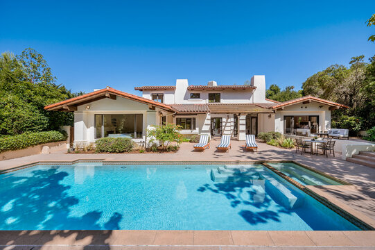 a house with a pool in the backyard and lots of greenery around it