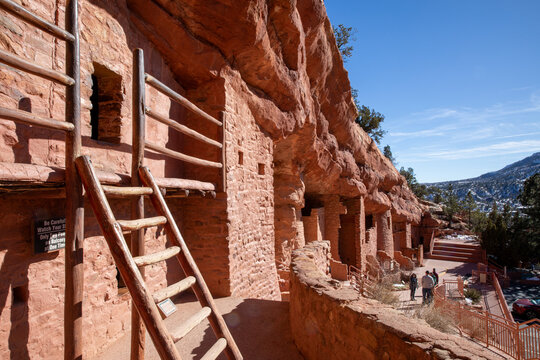 Red rocks of Manitou Springs cliff dwellings.  Natural adobe walls with stone and brick showing.  Native American ancestral structure with ladders shown.   