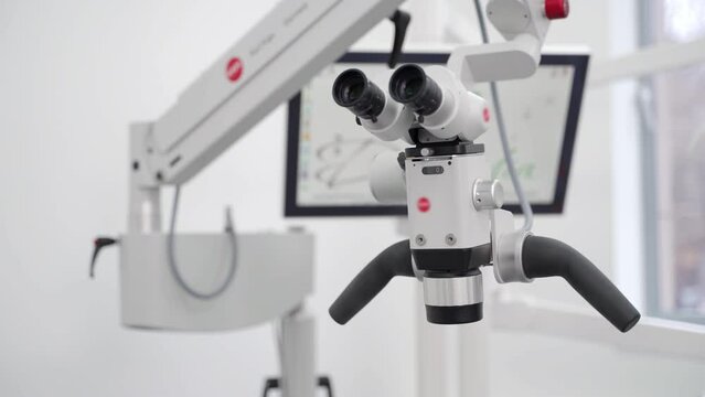 Dental surgical microscope with rotary binocular in modern dentist office. Using microscope in dental surgery. Professional equipment in the dentistry clinic. Diagnostics and treatment of teeth.