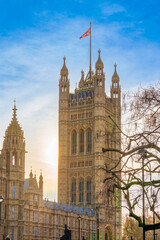Fototapeta na wymiar View of the victoria Tower from the Parliament Square Garden in golden hour time. The united flag is in the top