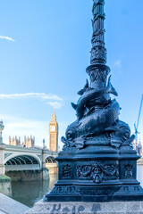 Fototapeta premium The Houses of Parliament, the Big Ben clock tower and Westminster Bridge with a lamppost adorned with a fish.