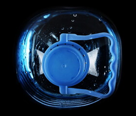 Close up plastic water bottle isolated on black, top view - 767396262