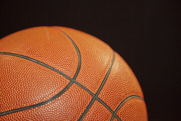 Close-up of a basketball on a black background, sports background