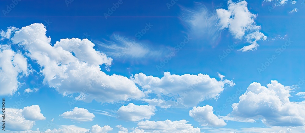 Wall mural the sky is filled with numerous clouds floating above a vast expanse of green grass in a scenic land