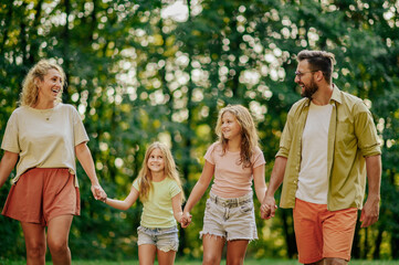 Fototapeta premium Portrait of a happy family walking together in nature.