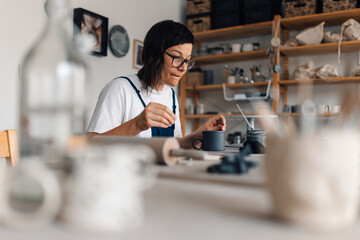 Talented pottery artisan at studio and making handmade earthenware.