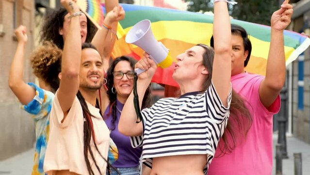 LGBTQ people with rainbow flags and a megaphone fighting for their rights. They are all smiling and celebrating Pride Parade.