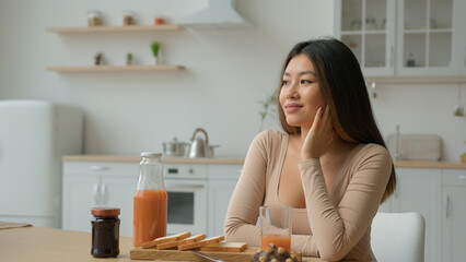 Asian ethnic dreamy woman in kitchen thoughtful chinese korean girl dreaming future think positive...