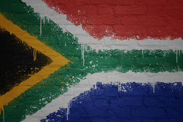 colorful painted big national flag of south africa on a massive brick wall