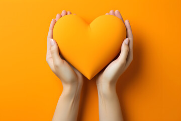 yellow decorative heart in hands. love and health concept. sacrifice and helping people