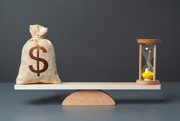 Dollar money bag and hourglass on scales. Find balance to get the most out of each. Investing money...