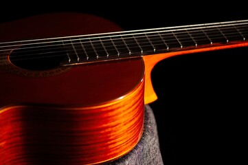 Fototapeta premium Classical Spanish flamenco guitar close up, dramatically lit isolated on black background with copy space.
