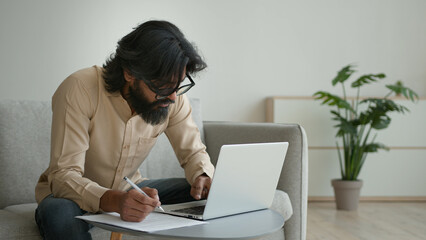 Arabian Indian muslim man guy businessman write notes papers paperwork writing statement document...