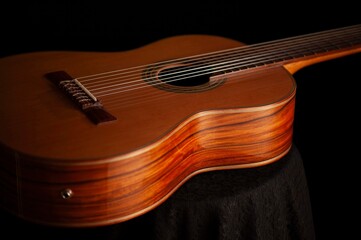 Classical Spanish flamenco guitar close up, dramatically lit isolated on black background with copy...