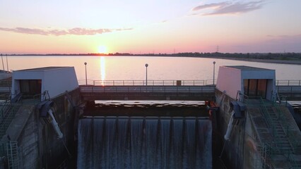  Aerial: hydroelectric power plant dam at sunset, water renewable energy